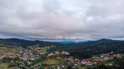 Aerial View Of A City Surrounded By Majestic Mountains Under A Cloudy Sky. The Dramatic Landscape Creates A Stunning Contrast Between Urban Life And Natural Beauty.	
