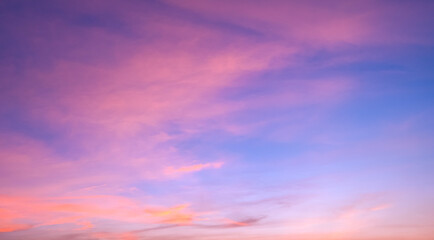 Sunset sky background with orange pink clouds on blue evening sky backdrop