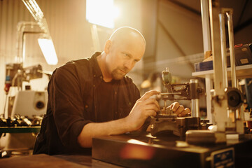 Mechanic working on precision machinery in workshop