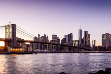 Fototapeta premium A panoramic sunset view of the Brooklyn Bridge stretching towards Manhattan