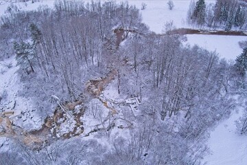 Aerial view of Kuhakoski rapids on a cold winter day with snow covered ground and tree branches, Nurmijärvi, Finland.