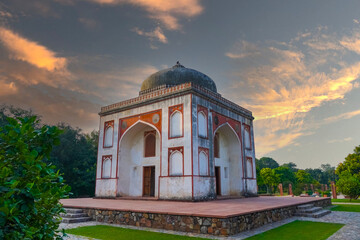 A scenic view of a Sunder Garden historic pavilion set against a colorful sunset, surrounded by...