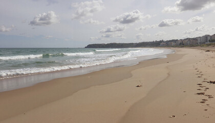 Calm beach scene with gentle waves and cloudy sky, nature's tranquility