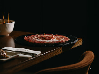 Ham on black plate on the table