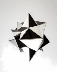 A geometric ceiling light, diamond-shaped, made of black and white metal with silver details.