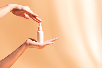 Woman hands hold white serum bottle