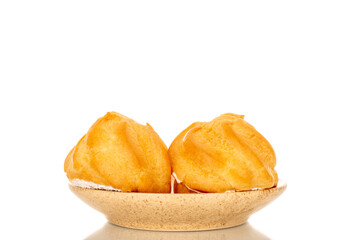 Two eclairs on a ceramic saucer on a white background, close-up.