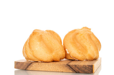 Two eclairs on a wooden tray  on a white background, close-up.