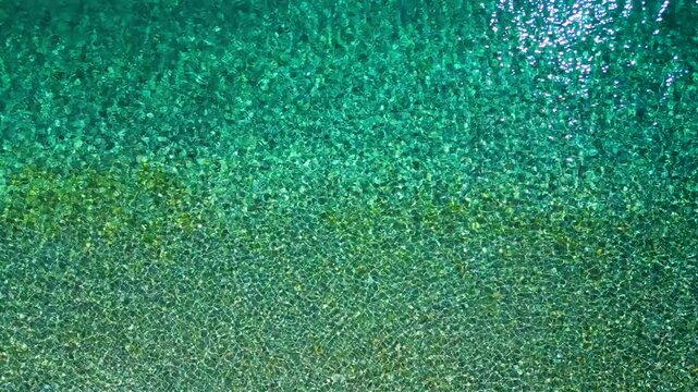 Top-down view of sea azure waves pattern and crystal clear water. Rhodes, Greece