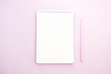 Notebook and a pencil on lilac background