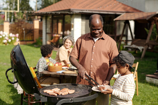 Family Gathering Eating Barbecue in Outdoors Area