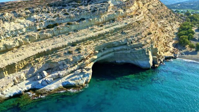 A stunning aerial view of Matala caves by the turquoise sea in Pitsidia, Greece