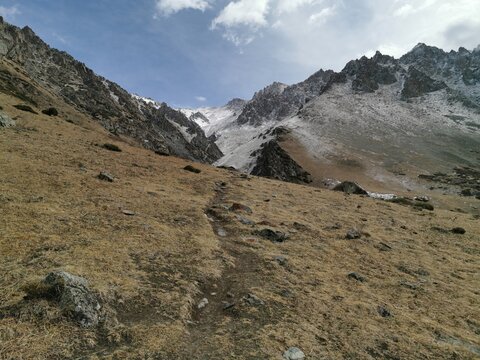 Hiking trail against the backdrop of mountains and sky in Ala-Archa National Park. The trail to Komsomolets Peak.