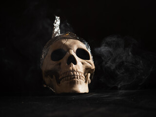 Skull with tin foil hat on smoking atmosphere background