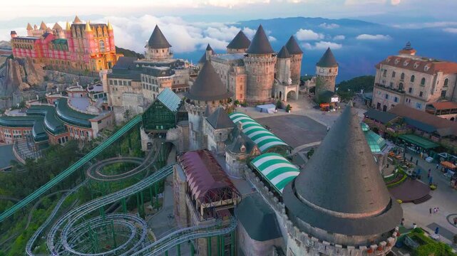 A whimsical amusement park with castle-like structures, roller coasters, and scenic views surrounded by clouds.