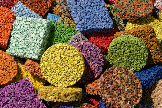 Multi-colored pieces of flooring made from painted rubber crumbs, products from recycling old car tires