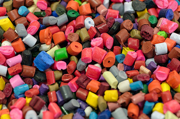 Lots of small pieces of multi-colored plastic, line for the production of plastic products or recycling