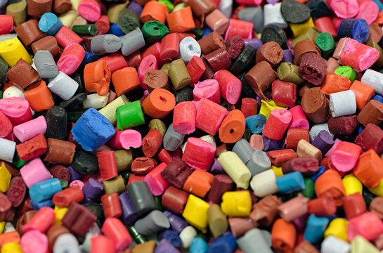 Lots of small pieces of multi-colored plastic, line for the production of plastic products or recycling