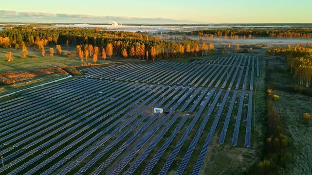 Drone orbit above solar panel field, renewable energy, breathtaking sunset in Latvia - 4k