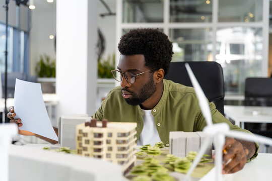 Young african american architect looking concentrated while working on a project - Powered by Adobe
