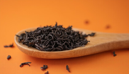 Dried organic black tea leaves on wooden spoon. Natural product.