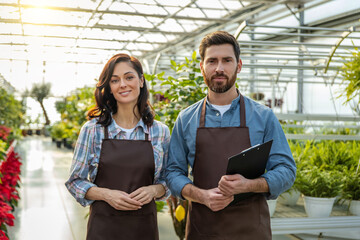 Two workers in a greenhouse looking positive and contented