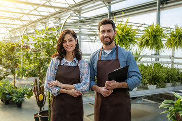 Two workers in a greenhouse looking positive and contented