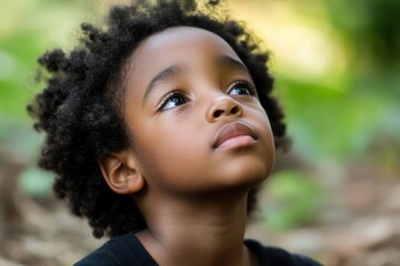 emotional portrait of young african american child in solitary moment, natural park setting, soft afternoon light emphasizing vulnerability
