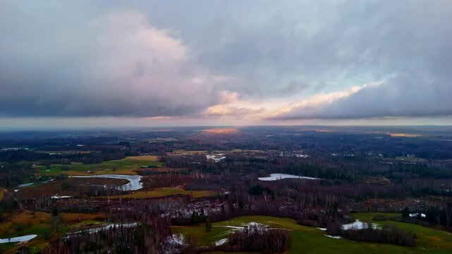 Wide angle tima lapse landscape with passing clouds, forest, fields and small lakes, epic view above, static, copy space