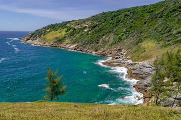 Obraz premium View from above of Foguete beach, with blue sea and sky, lots of rocks and mountains around. Cabo Frio, Rio de Janeiro.