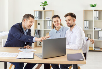 Portrait of young caucasian couple sitting with a business broker or insurance agent showing...
