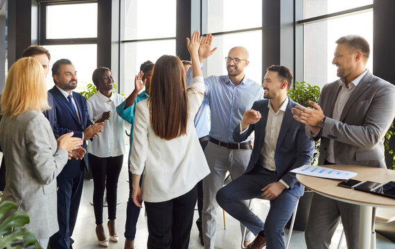 Friendly happy diverse employees congratulating with great business achievement, good work results or job promotion, business people applauding friend, hr cheering in modern office, promotion career