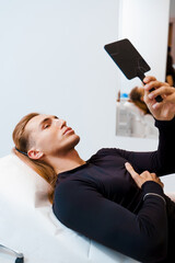 Man correction the shape of lower face and lips with filler injections by beautician. Man lips...