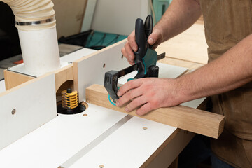 The carpenter is going to mill an oak part using a clamp and a special stop