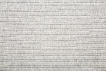 Light gray soft knitted fabric background. Empty place for text. Closeup. Top down view.