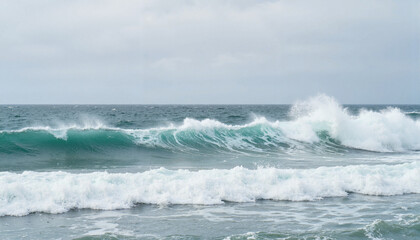 Waves crashing on a sandy beach under a cloudy sky