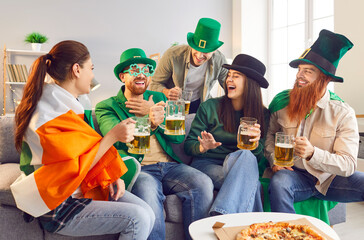 Friends gather at home to celebrate Saint Patrick Day, raising beer filled glasses. Dressed in green attire with shamrocks, company share laughter, cheers in honor of Ireland special day.