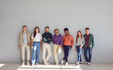 Multinational group of young people in casual wear, stands in full length view, radiating happy and...
