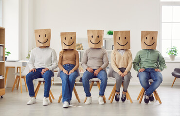 Group of people in paper bags with happy, smiling emoticon faces. Five casual males and females,...