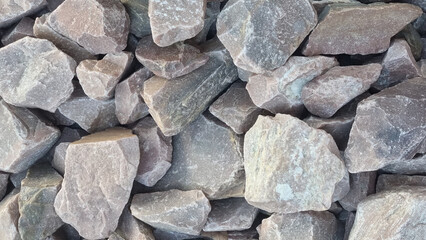 Close-up of natural brown and gray rocks with rough textures. Abstract background and material concept for design and print. Background with copy space. Horizontal format.