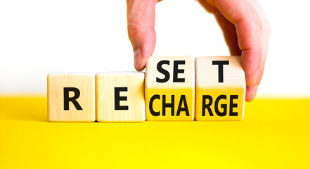Reset and recharge symbol. Concept words Reset Recharge on beautiful wooden block. Beautiful yellow...
