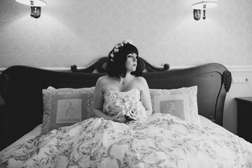 Gorgeous bride in robe posing and preparing for the wedding ceremony face in a room