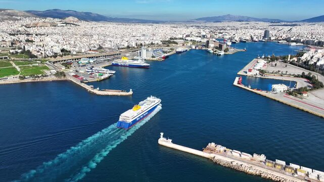 Aerial drone tracking photo of Blue Star Paros passenger ferry reaching destination - busy port of Piraeus