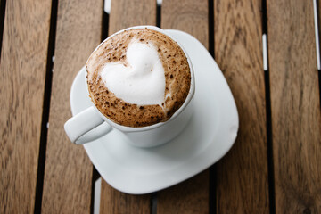 Taza de chocolate caliente con espuma en forma de corazón 