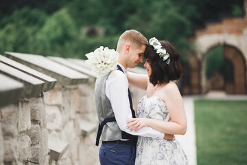 Wedding couple on the nature is hugging each other. Beautiful model girl in white dress. Man in suit