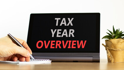 Tax year overview symbol. Concept words Tax year overview on beautiful black tablet. Beautiful white background. Businessman hand. Business tax year overview concept. Copy space.