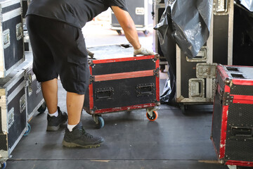 Technician moving and organizing work equipment on stage