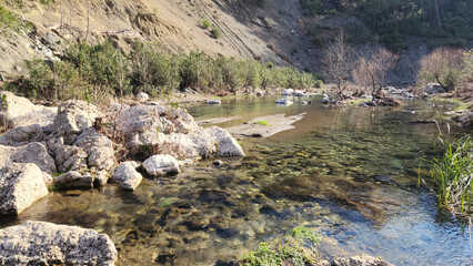 A view of the clean cold waters of Eğlence River among the rocks on a sunny winter day