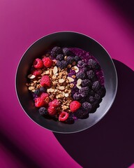 Colorful acai bowls topped with fresh blackberries, raspberries, granola, and almond slices in artistic lighting and textured bowls.