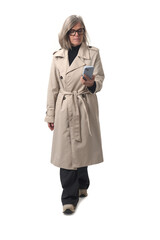 Front view of walking woman looking at her smartphone on white background